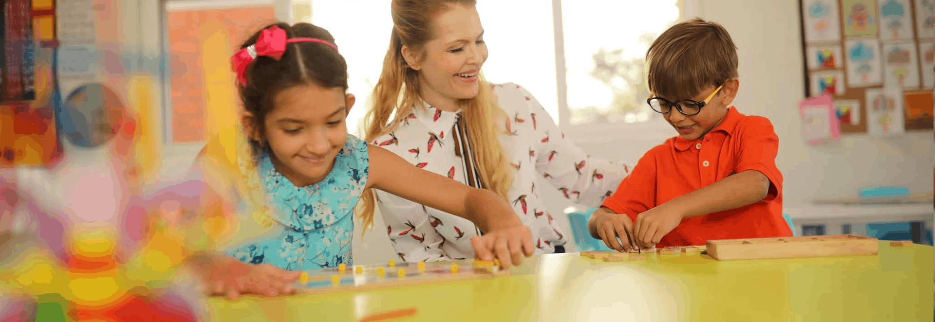 A teacher with small children happily performing activities inside a classroom.